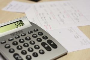 A calculator and some papers on a table.