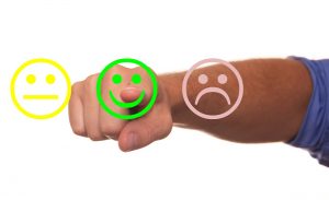 A person pointing a finger at a smiley face symbol 