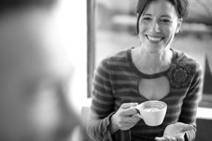 A woman holding a cup of coffee and smiling to local movers Nevada.