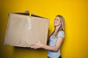 a girl holding a cardboard box