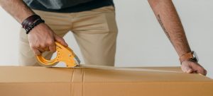 a man taping a cardboard box