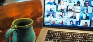 stay in touch after moving by talking with friends over video chat on the computer while drinking tea 