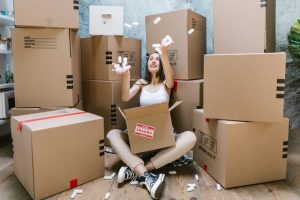 a woman playing with boxes - simplify your upcoming relocation