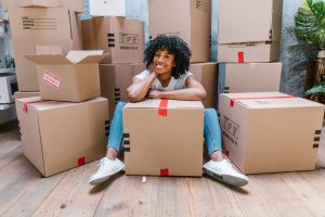 woman sitting between moving boxes