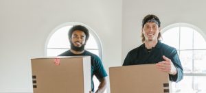 two movers holding packing boxes 