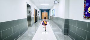 a kid running in a school hall