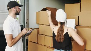 a man and a woman checking moving boxes