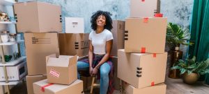 Girl sitting besides packed moving boxes