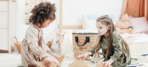 two girls playing with wooden toys while you are wondering how to organize your kid's new bedroom