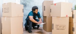 mover looking at cardboard boxes and planning on Finding the Best Deals on Moving Services